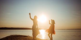 Mutter und Tochter tanzen am Strand