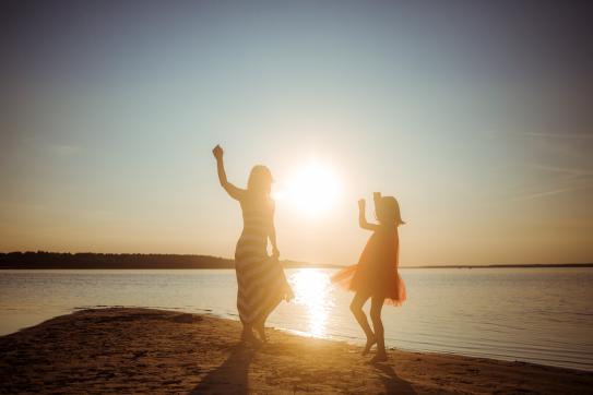 Mutter und Tochter tanzen am Strand