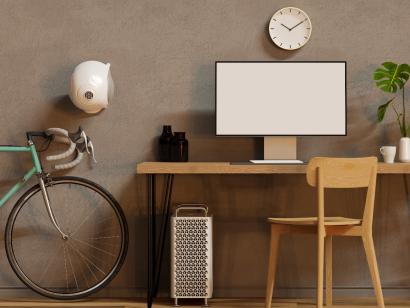 Schreibtisch mit Computer, Pflanzen und Fahrrad