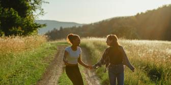 Zwei Mädchen laufen händchenhaltend über einen Feldweg